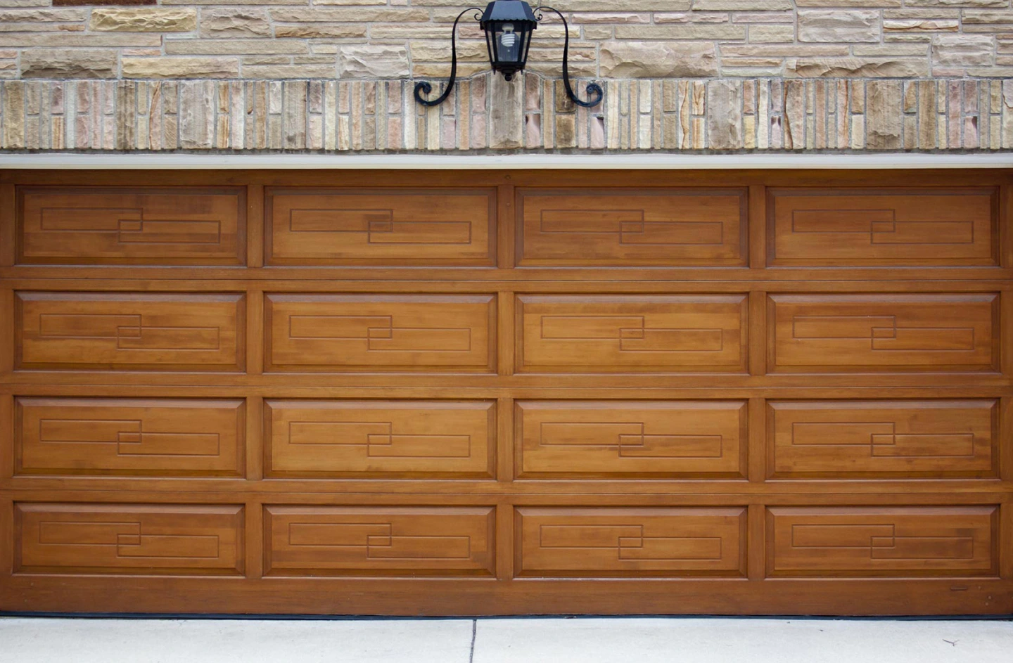 wood garage door of a home with stone cladding mint hill nc